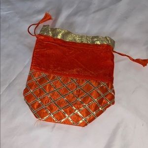 Orange pouch with gold pattern and drawstring